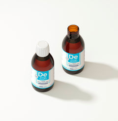 Two bottles of De3 Omega Benefits liquid on a white background