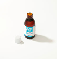 Bottle of De Omega Benefits liquid supplement with a white cap on a light background