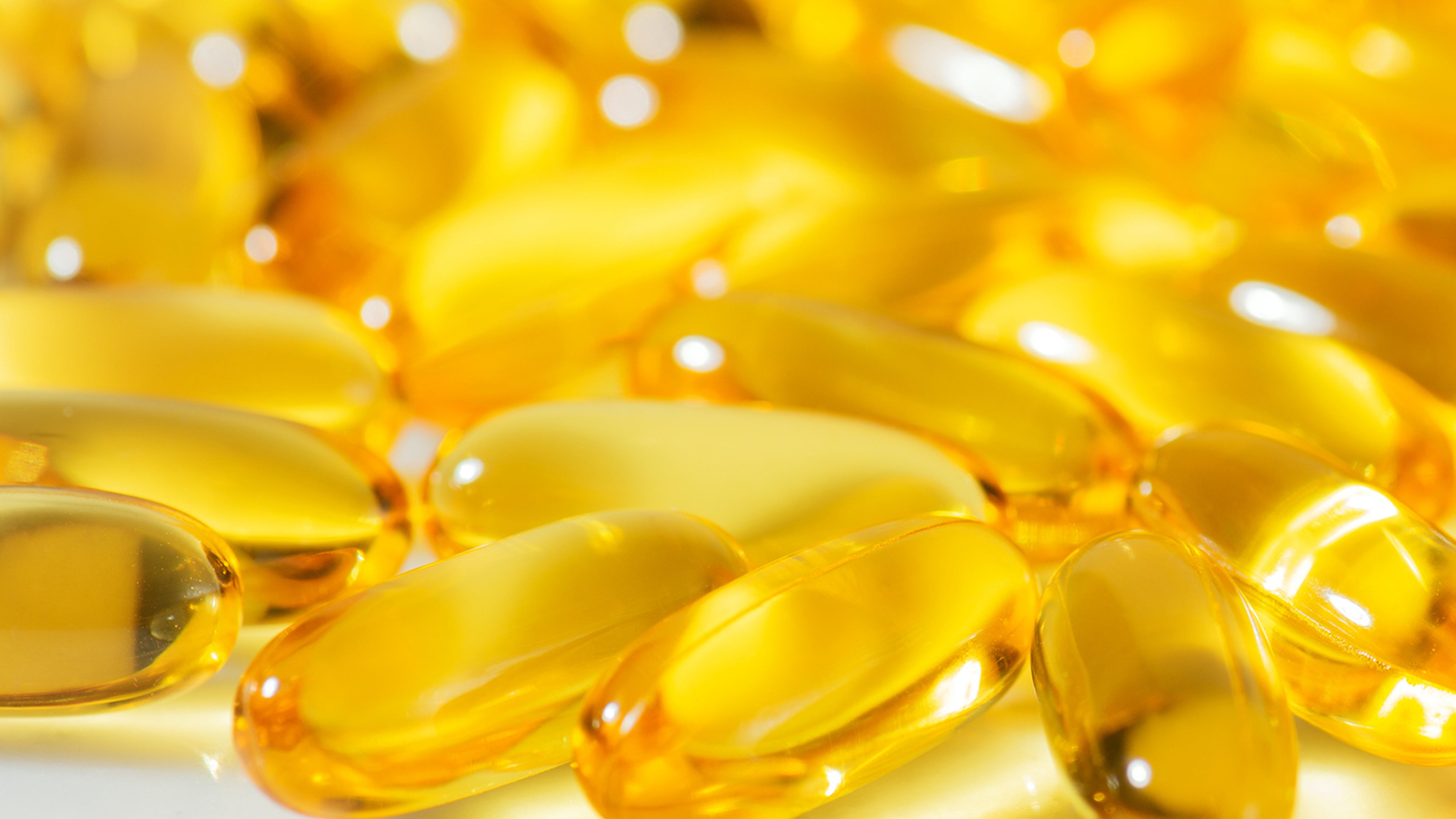 Close-up of yellow gel capsules on a white background